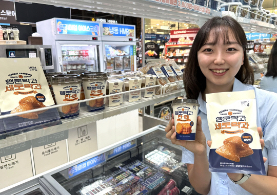 GS25 매장에서 모델이 행운약과라떼(음료), 행운약과세모약과(스낵)를 소개하고 있다. GS25 제공